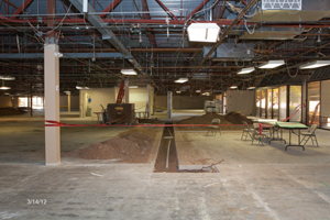 Inside gutted building with folding tables and chairs for charter school construction meeting