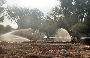 Sprinklers prepare dirt playground of traditional charter school for sod