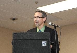 School Board President speaks from behind lectern at charter school ceremony