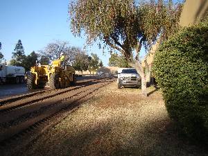 Charter school construction underway with grader and truck along building wall