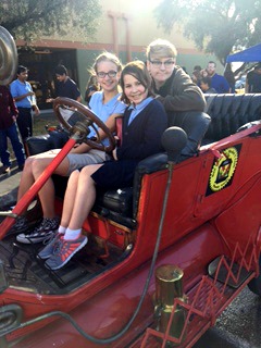 three middle school students in vintage car