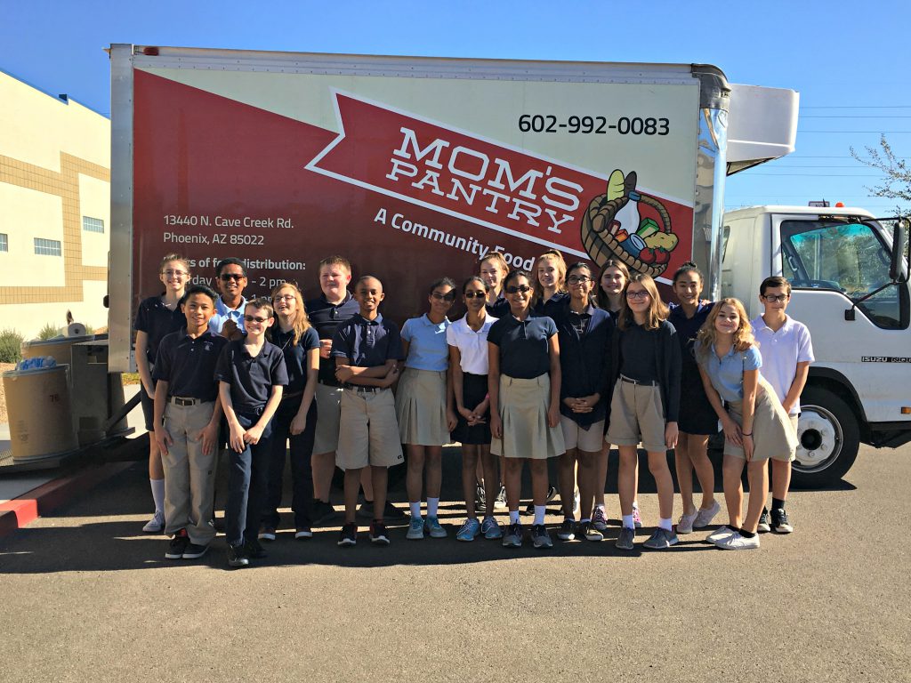 7th grade boys and girls in school uniforms in front of food pantry truck